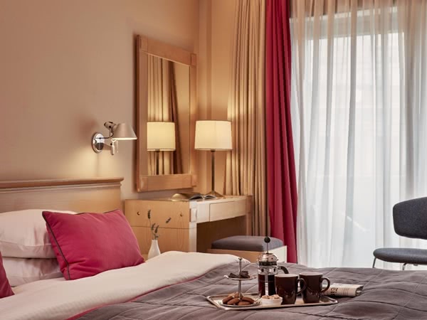 Hotelzimmer mit Doppelbett, auf dem ein Frühstückstablett steht